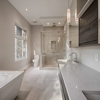 Armoire de rangement blanc avec douche en verre dans une salle de bain moderne.