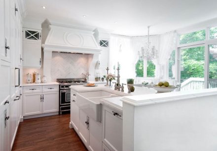Façade de cuisine moderne avec armoires blanches et dosseret en carreaux clairs.