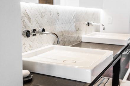 Superbe salle de bain contemporaine blanche avec dosseret à motifs chevrons.