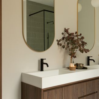 Custom made vanity with dark wood, and oval mirrors